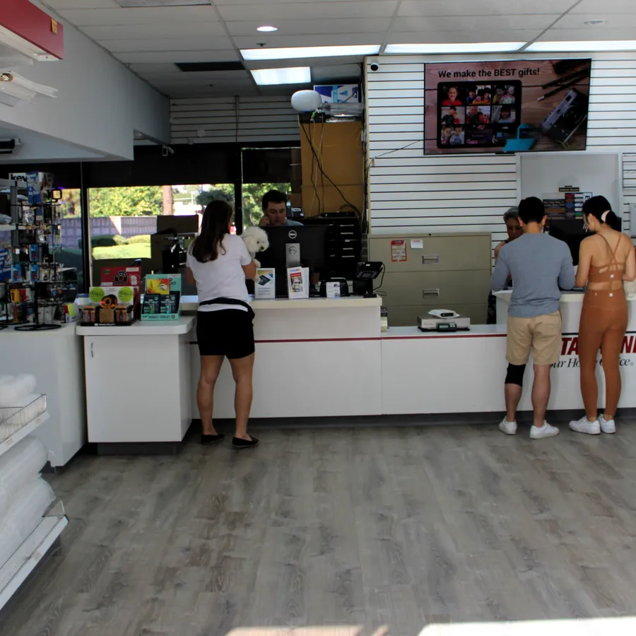 Staff helping customers at the service counter of PostalAnnex Branham